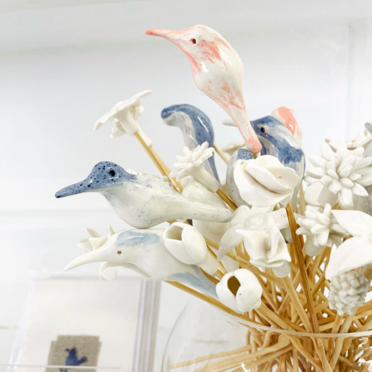 Decorative arrangement of marbled bird diffuser sticks on a white background