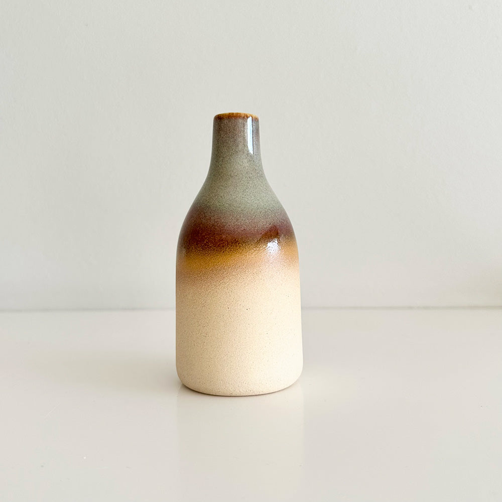 Ceramic bottle with gradient color on a plain background