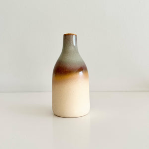 Ceramic bottle with gradient color on a plain background