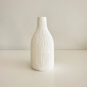 White textured vase on a light beige background