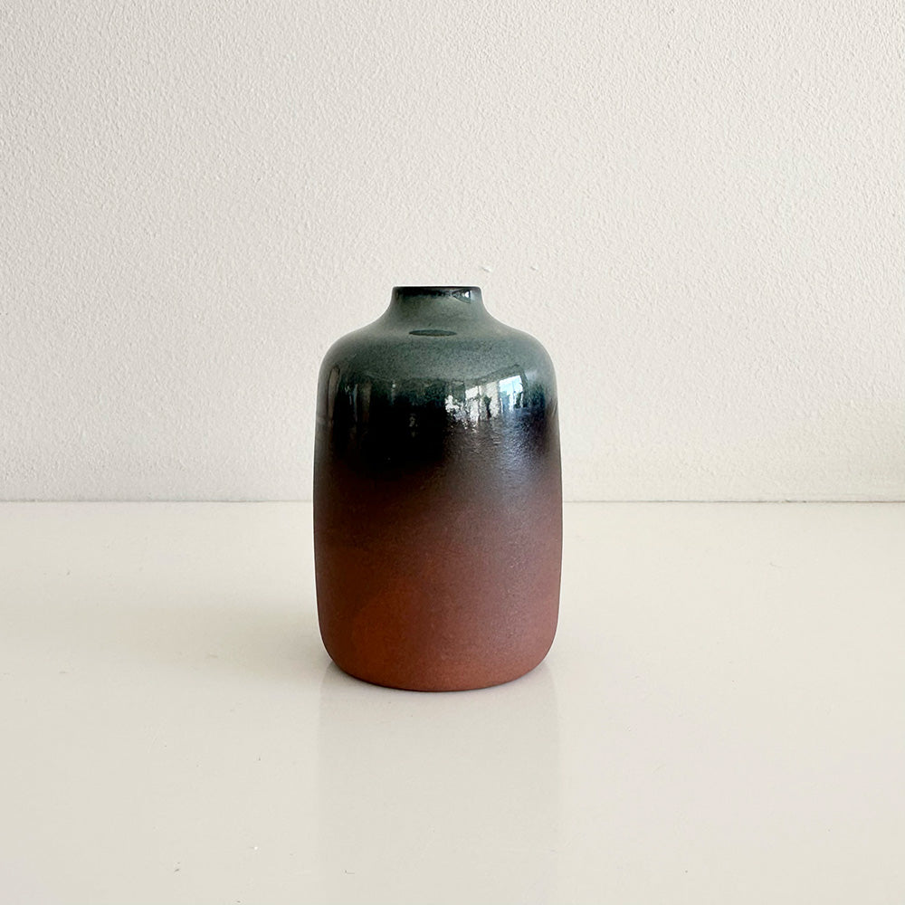 Ceramic vase with gradient color from black to brown on a white background