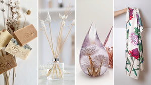A slider with four images displaying from left to right an assortment of handmade soap bars, ceramic reed diffuser sticks, a resin teardrop fynbos drop with a cape snow flower embedded, and a cream silk scarf with colourful protea illustrations. 