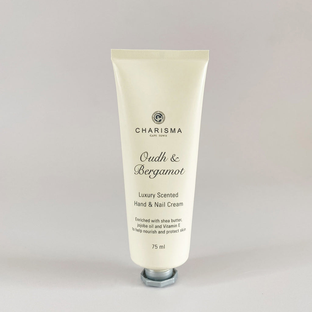 A tube of Charisma brand oud and bergamot luxury hand and nail cream, with the label indicating it is scented with natural essences.