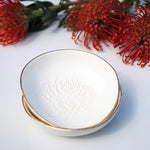 Load image into Gallery viewer, Two stacked dipping bowls imprinted with a pincushion protea motif and gold detailing around the rim.

