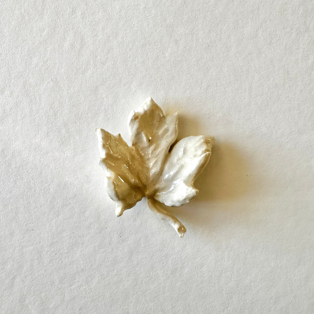 White leaf-shaped ceramic on a light gray background