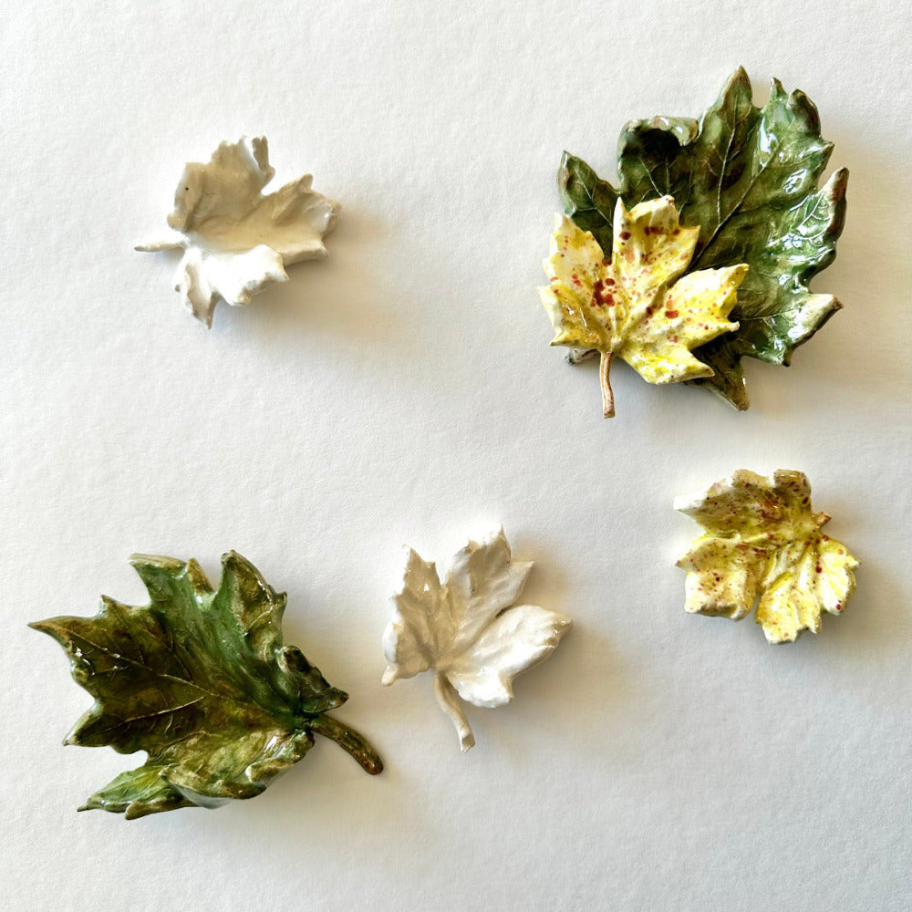 Five leaf-shaped ceramics on a white background