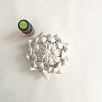 Load image into Gallery viewer, A bisquewear ceramic protea sculpture alongside a frangrance oil bottle on a white background.
