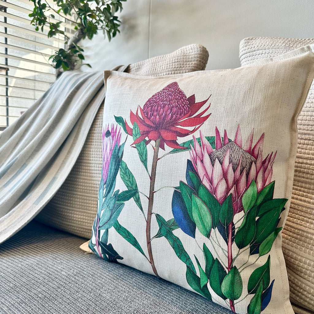 Decorative pillow with protea floral design on a couch