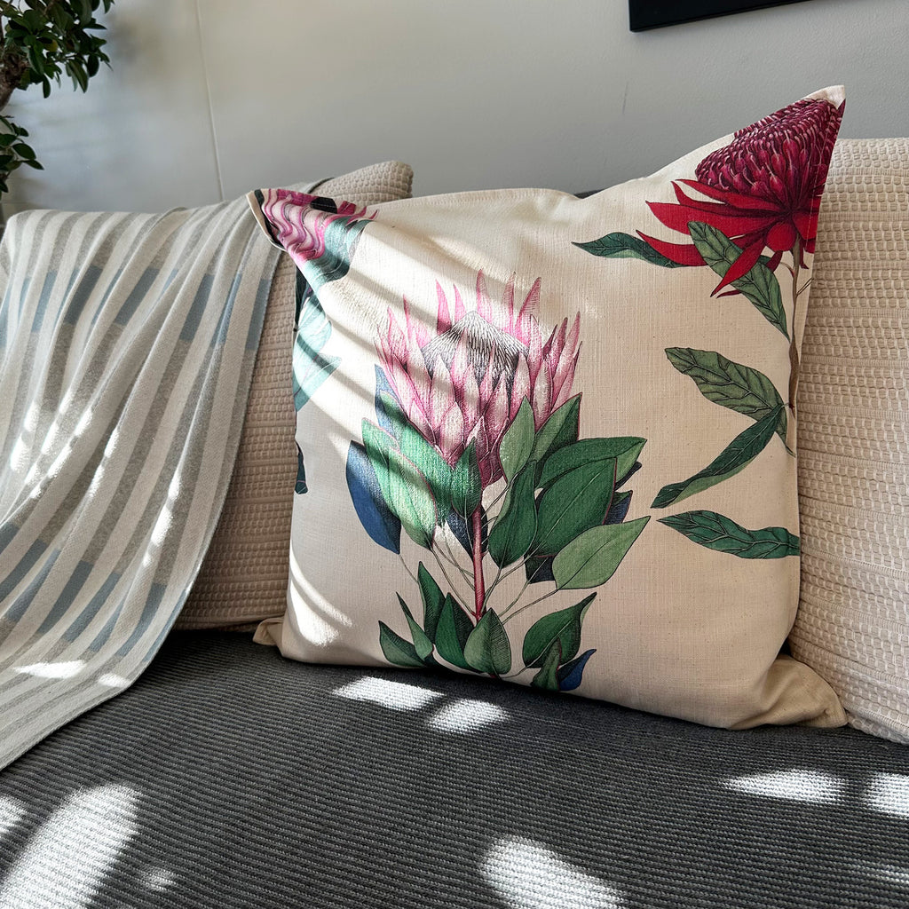 Decorative pillow with protea floral design on a couch
