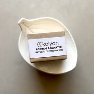 Kalyan natural cleansing bar on a beige plate with a neutral background