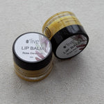 Load image into Gallery viewer, Two lip balm containers with visible labels on a light gray background
