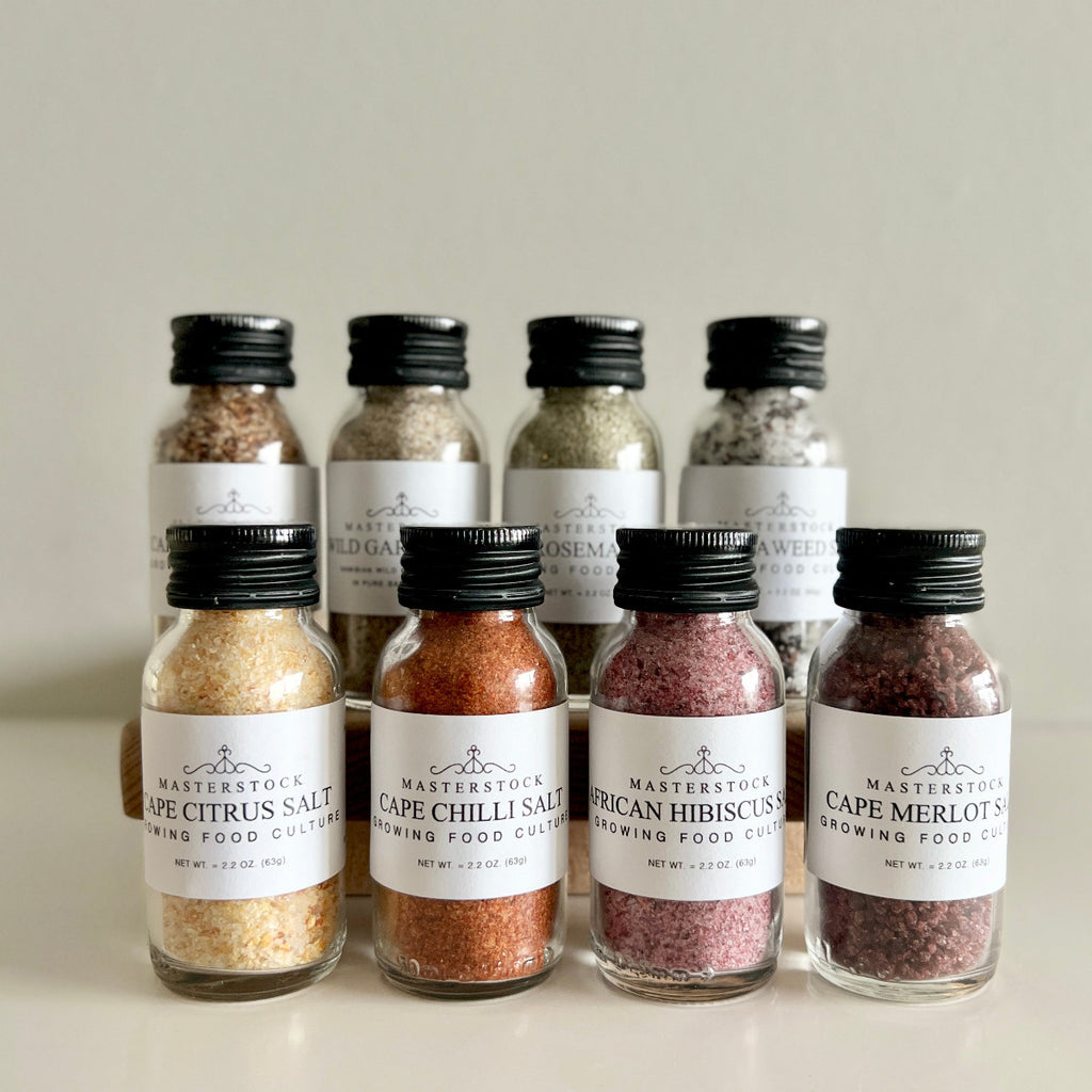 Collection of small bottles of salt with labels on a neutral background