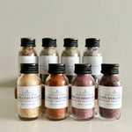 Load image into Gallery viewer, Collection of small bottles of salt with labels on a neutral background
