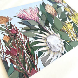 Floral design with protea flowers and leaves on a blue background