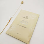 Load image into Gallery viewer, A cream coloured sachet with the title &#39;OUDH &amp; BERGAMOT LUXURY SCENTED SACHET&#39; in silver foiling alongside a dried grass.
