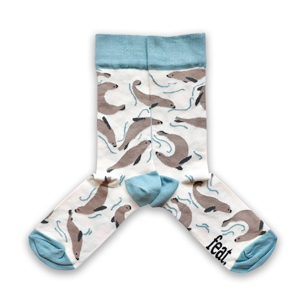 Cotton socks with grey seal patterns on a cream background and blue accents on the heel, toe, and ribbing.