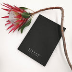 Load image into Gallery viewer, A black scarf box with silver foiled embossed branding.
