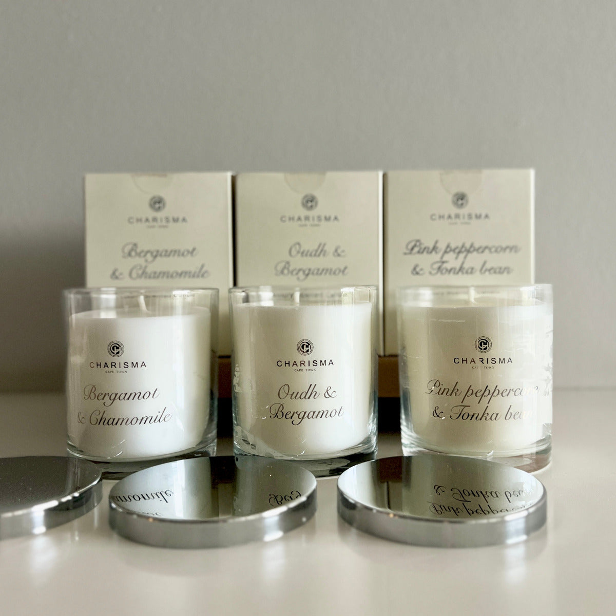 Three Charisma candles with their packaging.