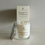 Load image into Gallery viewer, Glass candle with &#39;Charisma&#39; branding and a box in the background on a light surface.
