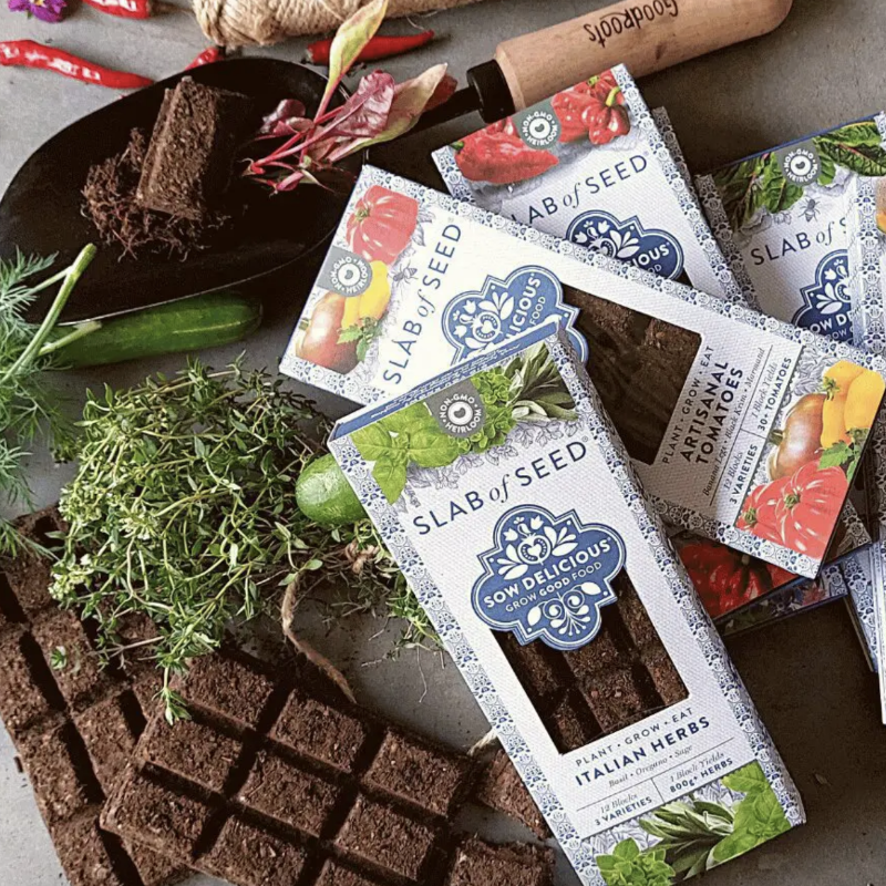 Slab of Seed packaging with brownies and herbs on a rustic background