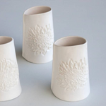 Load image into Gallery viewer, Three white ceramic dressing jugs with protea embossed design on a gray background

