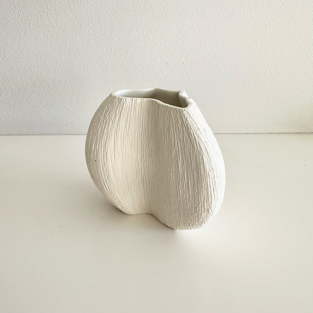 White ceramic vase on a light gray background