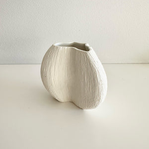 White ceramic vase on a light gray background