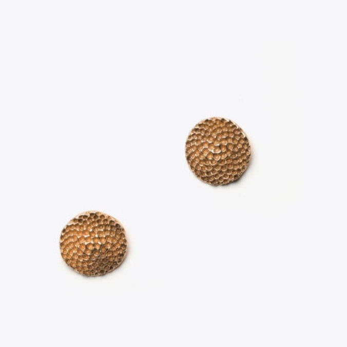 Pair of bronze textured round earrings on a white background