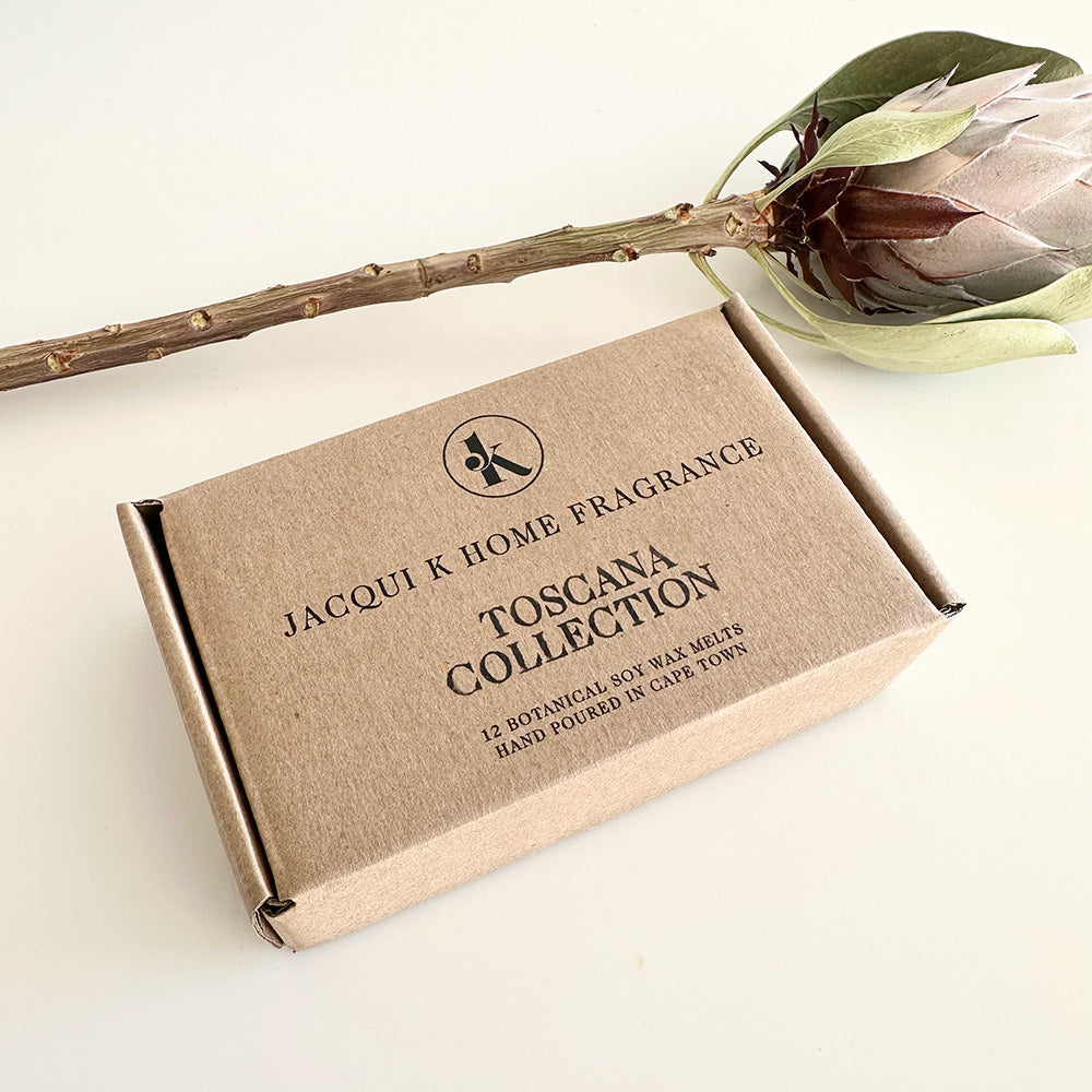 Jacqui K Home Fragrance Toscana Collection box with a king protea on a light background