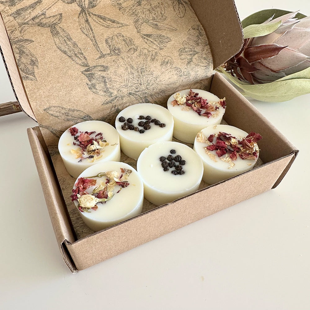 Box of white wax melts with natural ingredients on a light surface