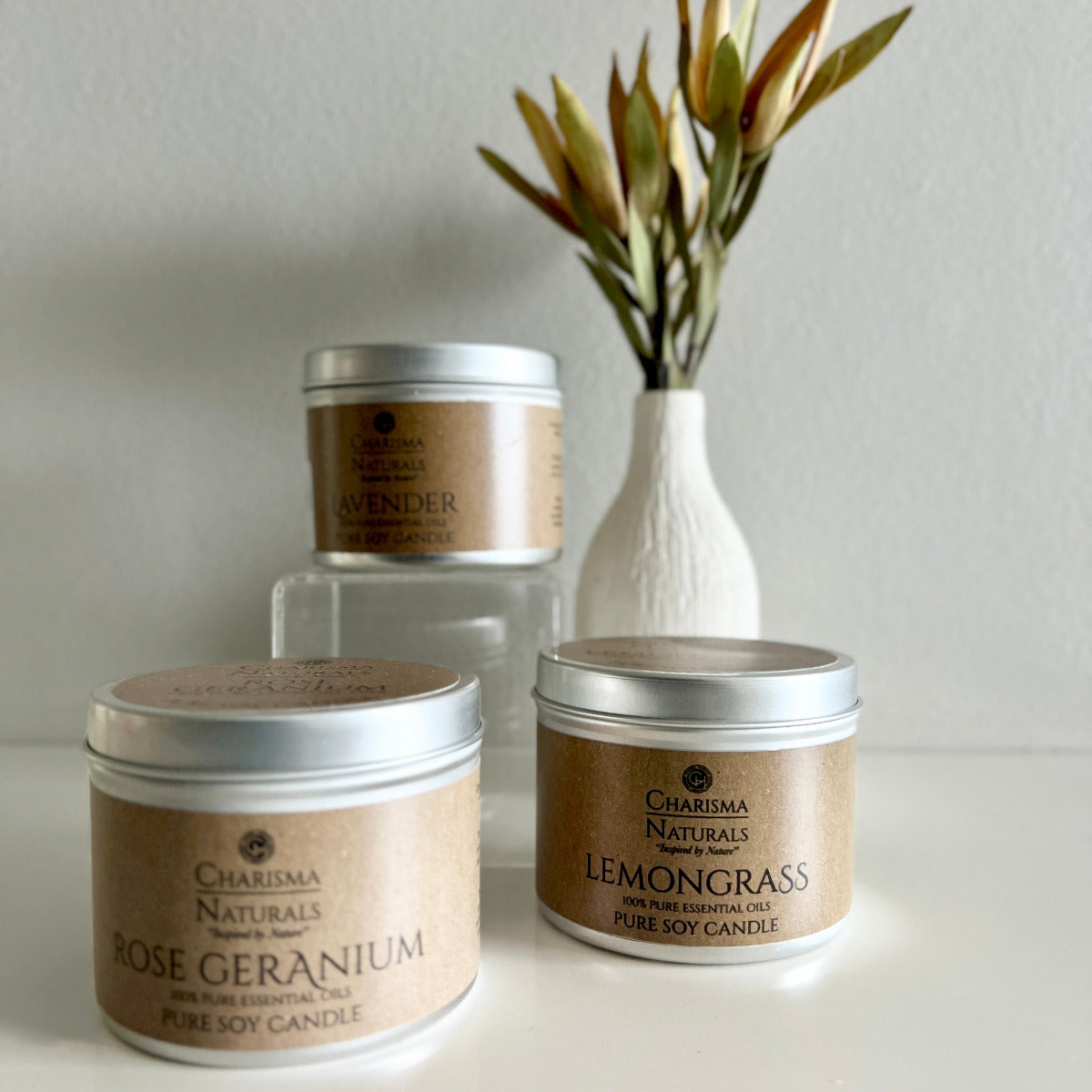 Three Charisma Naturals candles with different scents on a neutral background