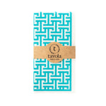 Load image into Gallery viewer, Turquoise and white patterned napkin with a brown label on a white background.
