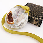 Load image into Gallery viewer, Decorative wax tablet with citrus peel and a yellow ribbon, with a box labeled &#39;Scented Wax Tablet Lemongrass&#39; in the background.
