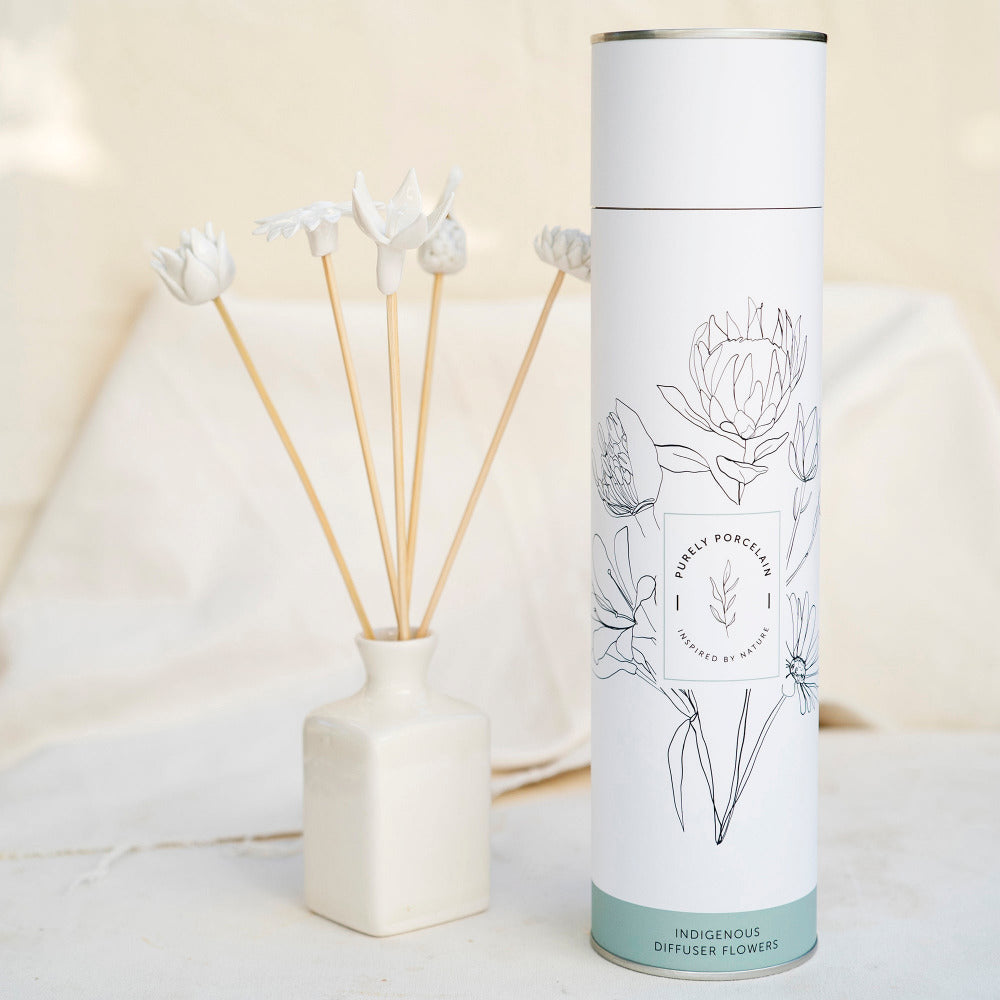 Diffuser flowers with a cylindrical packaging tube featuring floral illustrations on a light background