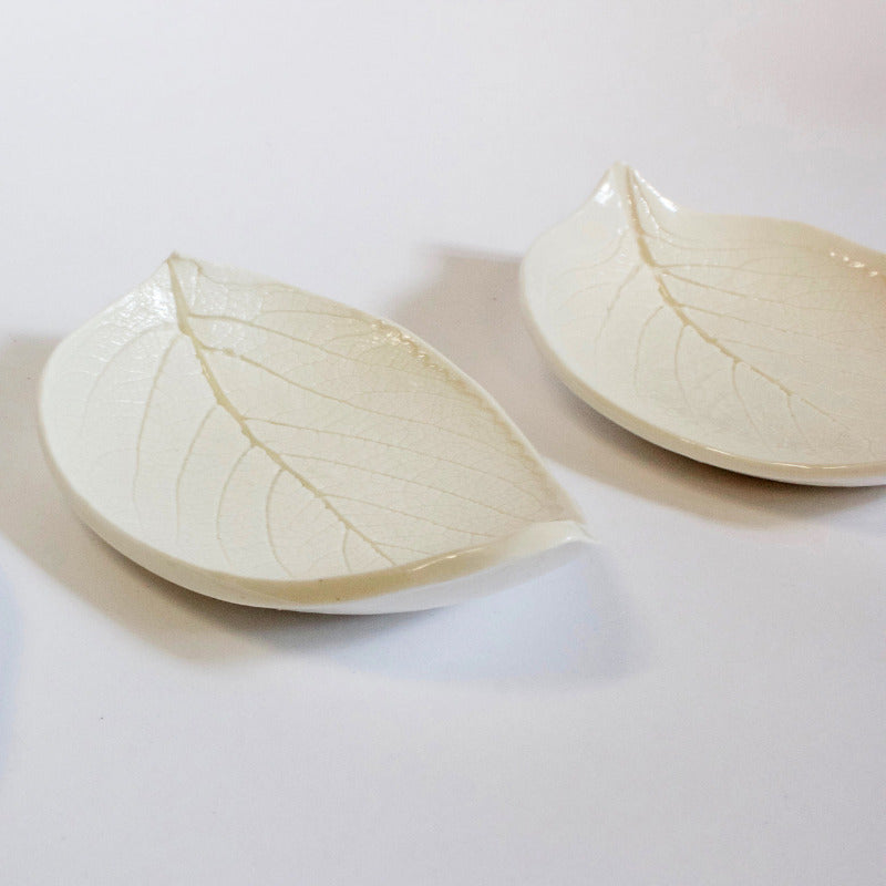Two porcelain leaf-shaped dishes on a white background.