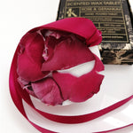 Load image into Gallery viewer, Scented wax tablet with rose and geranium fragrance on a white base with packaging in the background
